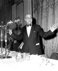 Premier Smallwood standing in front of microphones